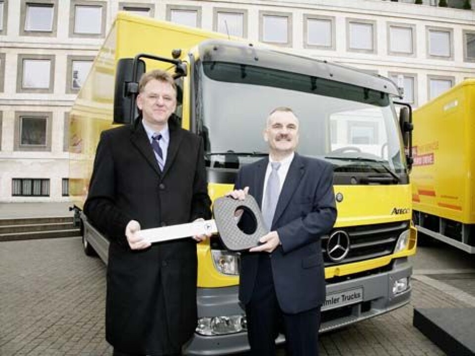 Daimler AGs Andreas Renschler (t.v) og Christian Stiefelhagen, styremedlem i DHLs postdivisjon, foran en Mercedes-Benz Atego BlueTec Hybrid.