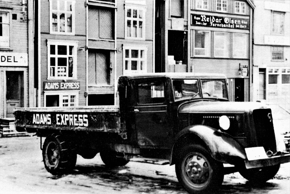 Trondheim: Adams Express hadde denne Volvo av førkrigsmodell. Farge dyp rød med hvite bokstaver. Bak ser vi firmaets brygge i Kjøpmannsgata 83, som sammen med resten av bryggerekka brant ned i 1967. Royal Garden Hotell ble senere bygd på tomta. (Foto og opplysninger fra Knut Hassel via Ivar Stav)